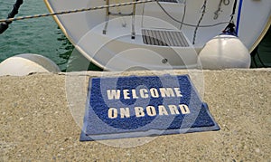 Welcome on board text on carpet across the sea and boat in the harbour. transportation