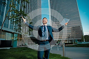 Welcome business. Happy leader standing in front of company building make winner gesture.