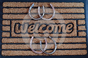 Welcome door mat with horseshoes