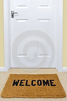 Welcome doormat outside a door. photo