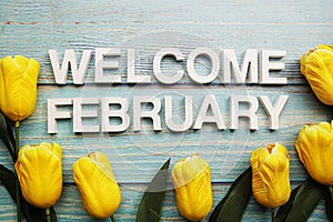 Welcome February alphabet letters with tulip flower on wooden background