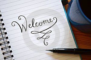 WELCOME hand-lettered in notebook