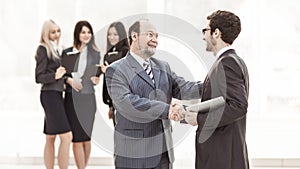 Welcome handshake Manager and client on the background of business team