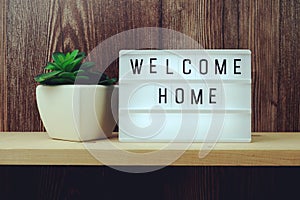 Welcome Home word in light box on wooden background