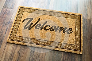 Welcome Mat On A Wood Floor Background photo