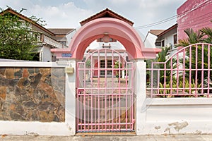 Welcome pink gate, pink fence white walls, stone wall.  A house in the village
