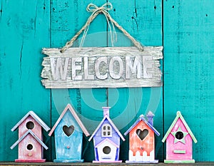 Welcome sign with bow by collection of birdhouses