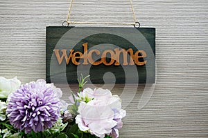 Welcome Sign and flower bouquet decoration on wooden background