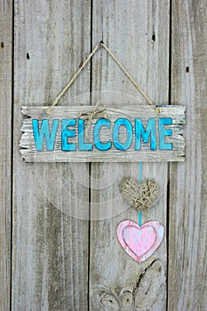 Welcome sign with hearts hanging on door