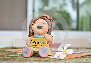 Welcome sign stone doll with white flower on the table