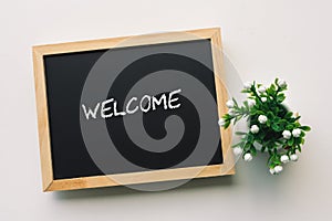 WELCOME text in white chalk handwriting on a blackboard