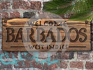 Welcome to Barbados Wood Sign on Brick Wall with Palm Leaf