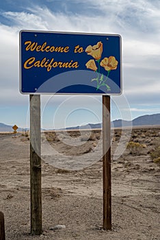 Welcome to California road sign in desert with mountains