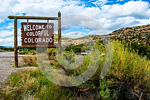 Welcome to Colorful Colorado Sign next to big Yellow Wild Bush