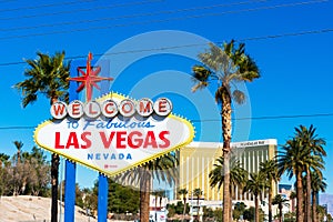 Welcome to Fabulous Las Vegas sign at The Strip on a bright sunny day. Mandalay Bay Resort and Casino tower in background