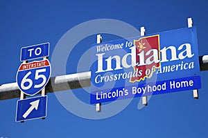 Welcome to Indiana road sign against blue sky.