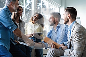 Welcome to our team! Business men in smart casual wear shaking hands while working in the creative office.