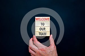 Welcome to our team symbol. Concept words Welcome to our team on wooden blocks on a beautiful black table black background.