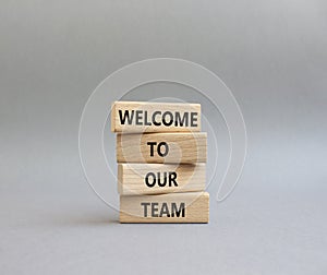 Welcome to our team symbol. Concept words Welcome to our team on wooden blocks. Beautiful grey background. Business and Welcome to