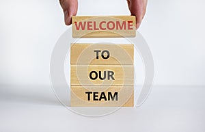 Welcome to our team symbol. Concept words `Welcome to our team` on wooden blocks on a beautiful white background. Businessman ha