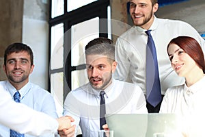 Welcome to our team. Young modern businessmen shaking hands while working in the creative office