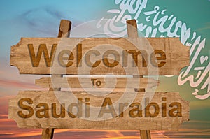 Welcome to Saudi Arabia sign on wood background with blending national flag