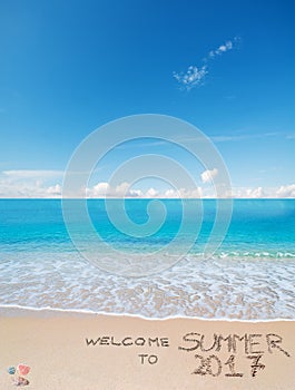 Welcome to summer 2017 written on a tropical beach