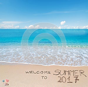 Welcome to summer 2017 written on a tropical beach