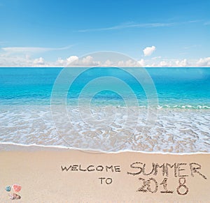 Welcome to summer 2018 written on a tropical beach