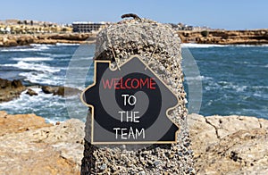 Welcome to the team symbol. Concept words Welcome to the team on beautiful black chalk blackboard. Beautiful red stone blue sea