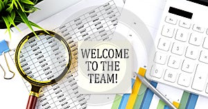 WELCOME TO THE TEAM text on sticker on diagram with magnifier and calculator. Business concept