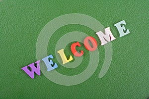 WELCOME word on green background composed from colorful abc alphabet block wooden letters, copy space for ad text. Learning