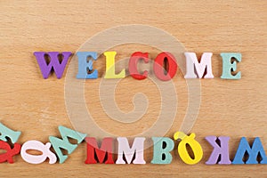 WELCOME word on wooden background composed from colorful abc alphabet block wooden letters, copy space for ad text. Learning