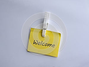 Welcome written on clipped yellow note