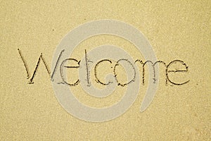 Welcome written on sand at the beach