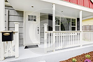 Welcoming front porch boasts pure white front door.