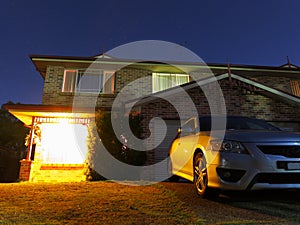 Welcoming home at night with parked car