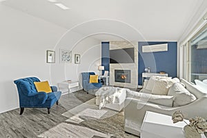 Welcoming living room with a blue accent wall, white faux fur pillows and a modern fireplace