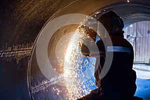 Welder carries out mechanical cleaning of root surfaces of weld