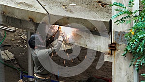 Welder at a construction site. Welding work at a construction site. A worker in a special mask