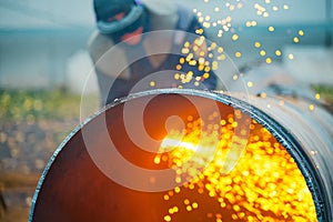 The welder cuts large metal pipes with ocetylene welding.
