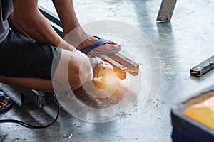 Welder cutting metal with electric grinding machine and sparks