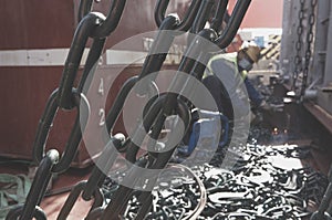 Welder doing welding on deck of ship lashing cargo