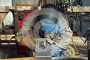 A welder fabricates steel structures using semi-automatic weldin