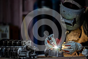 Welder in face mask welds with argon arc stainless steel welding, Industrial worker at the factory welding steel structure, Welder