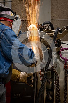 A welder grinding and welding