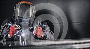 Welder industrial worker welding with argon machine