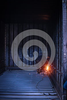Welder makes welding inside an iron container