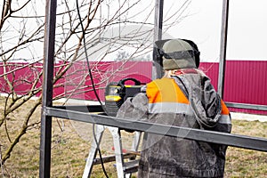 the welder makes welding of metal structures from a profile pipe with an electric welding machine. Construction of a