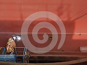 Welder in Man Lift Welding On Ship Hull